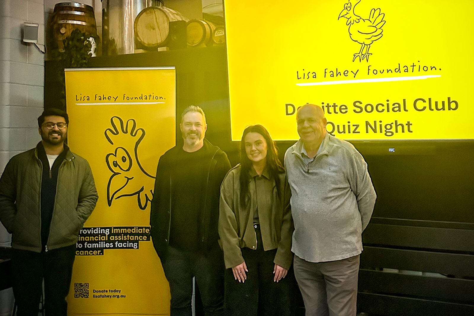 Board members in front of the Deloitte Social Club Quiz Night screen