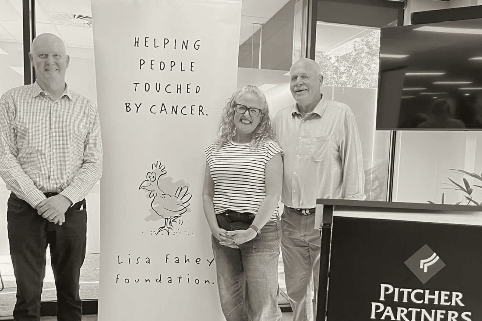 Foundation and Pitcher Partners representatives beside the Lisa Fahey Foundation banner
